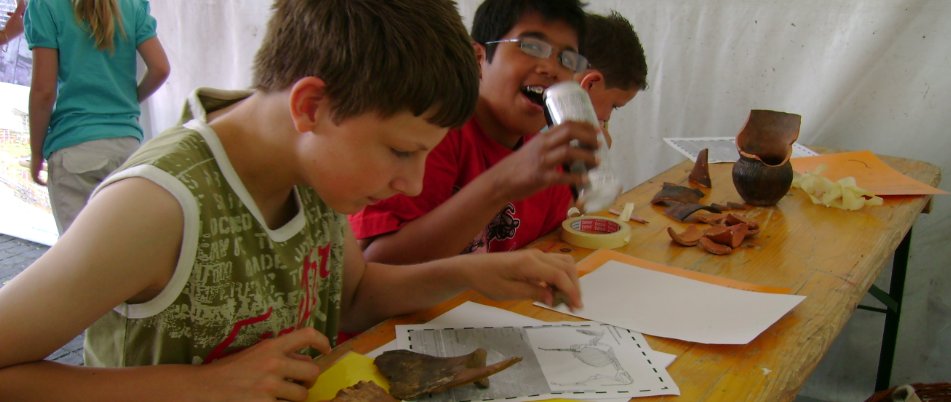 children studying archaeological finds